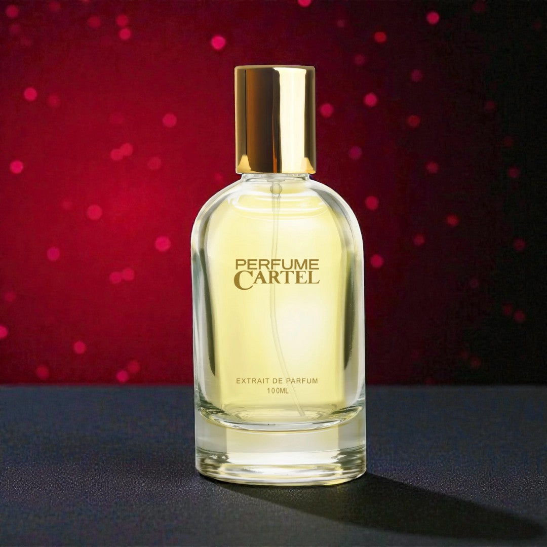 Perfume Cartel bottle with gold cap on a dark surface against a red background