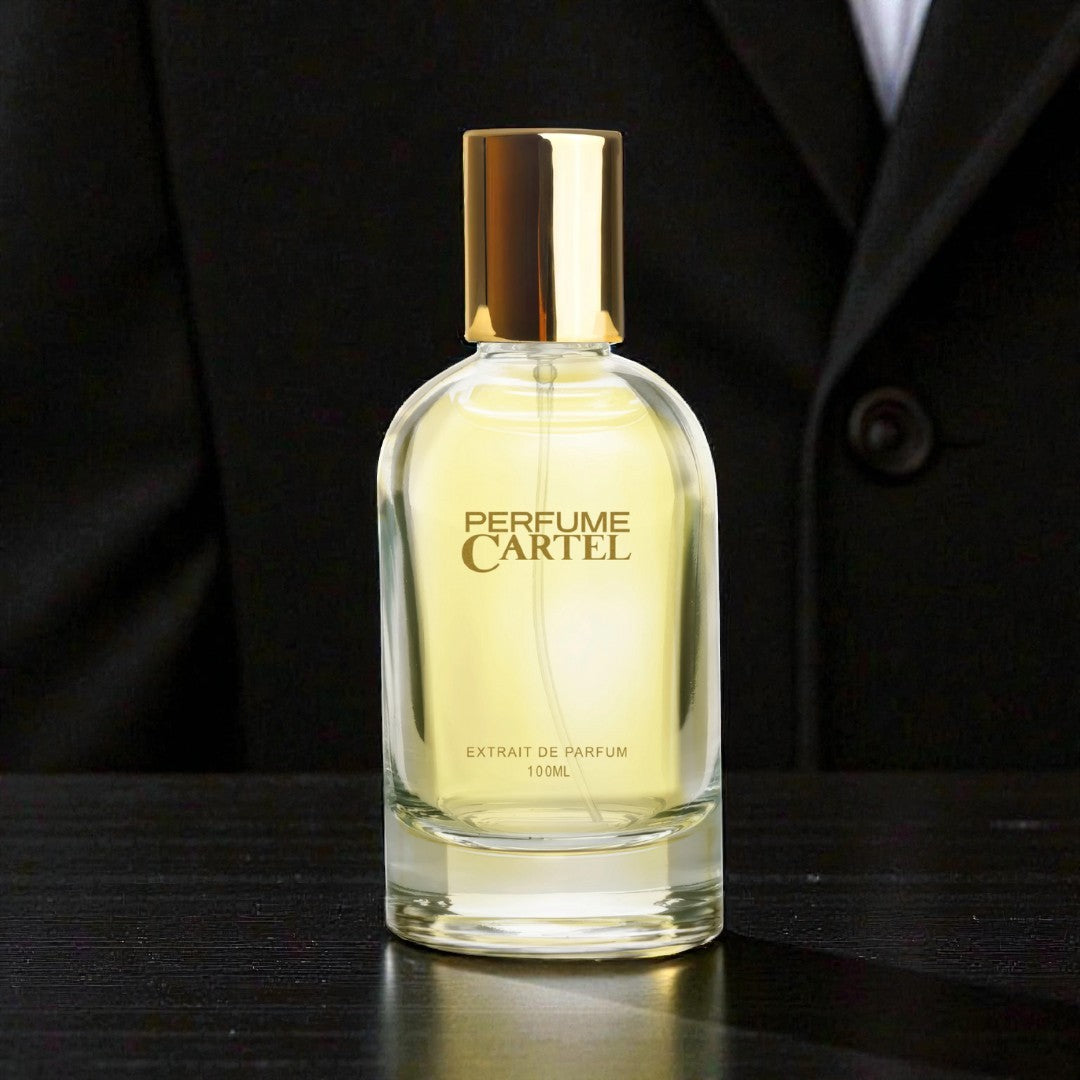Perfume Cartel bottle on a dark surface with a suit in the background