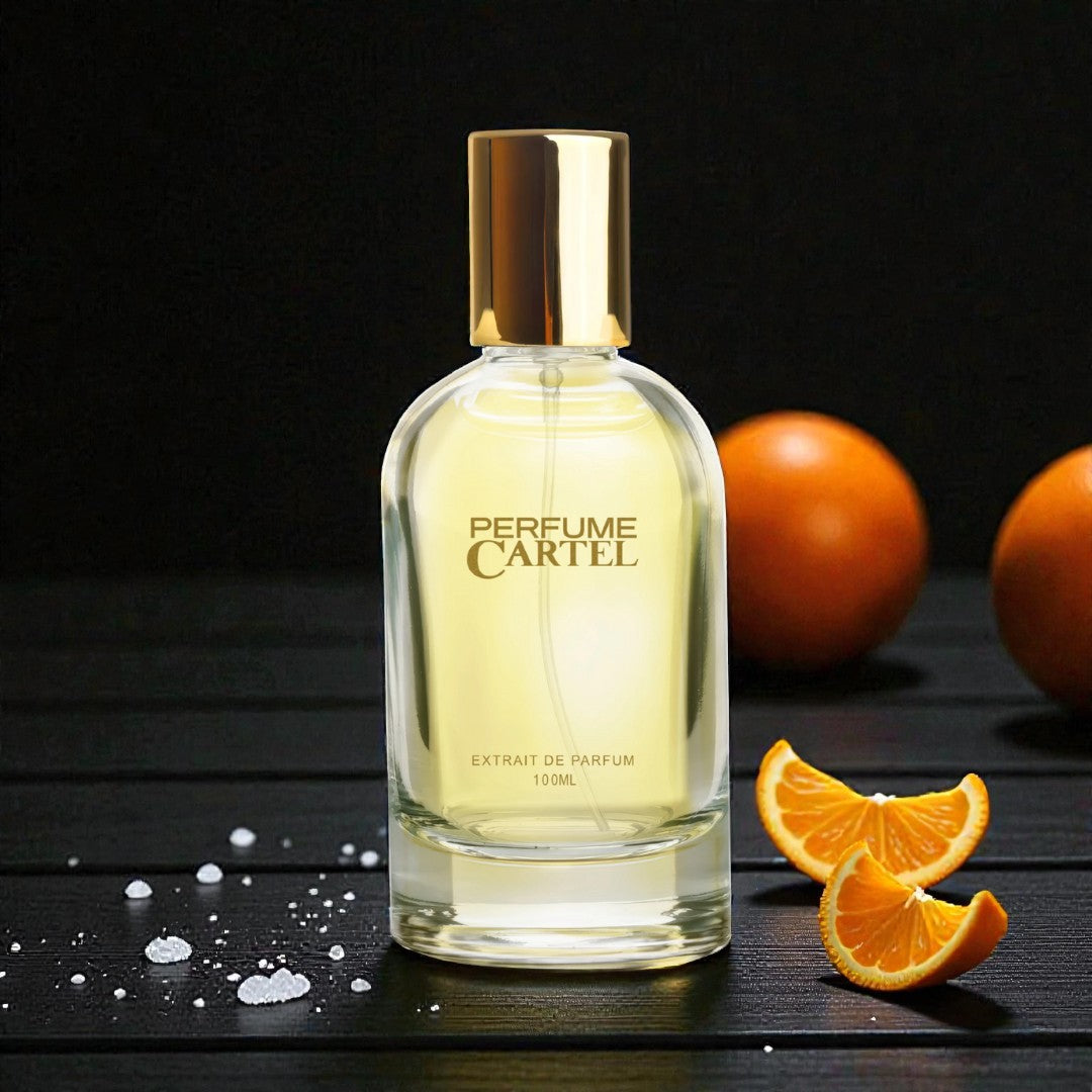 Perfume Cartel bottle with oranges on a dark surface